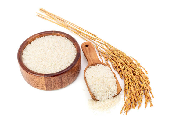 Rice in a brown wooden bowl, top view with yellow ears of rice separated from the background