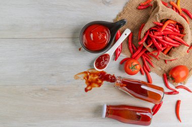Ketçap, acı biber sosu, plastik sos şişeleri ve cam şişeler mutfaktaki ahşap masa, üst manzara.