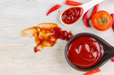 Ketçap, acı biber sosu, plastik sos şişeleri ve cam şişeler mutfaktaki ahşap masa, üst manzara.