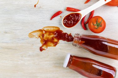 Ketçap, acı biber sosu, plastik sos şişeleri ve cam şişeler mutfaktaki ahşap masa, üst manzara.