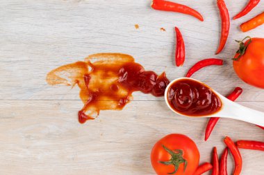 Ketçap, acı biber sosu, plastik sos şişeleri ve cam şişeler mutfaktaki ahşap masa, üst manzara.