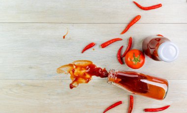 Ketçap, acı biber sosu, plastik sos şişeleri ve cam şişeler mutfaktaki ahşap masa, üst manzara.