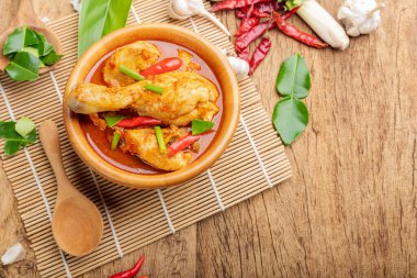 Körili tavuk Asya yemeği masalası. Geleneksel baharatlı sağlıklı yemek pişirme. Ahşap masa arkaplanına yerleştirilmiş.