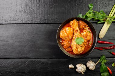 Körili tavuk Asya yemeği masalası. Geleneksel baharatlı sağlıklı yemek pişirme. Siyah ahşap masa arkaplanına yerleştirilmiş.