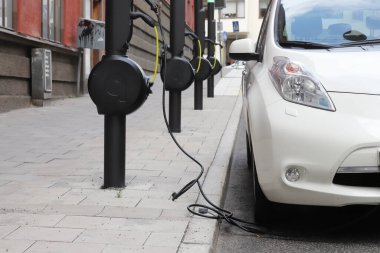 Stockholm, İsveç - 13 Temmuz 2023: Elektrikli araçların sokak otoparkında kullanılmak üzere Qwello tarafından işletilen kamu ücret noktaları.