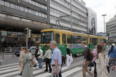 Helsinki, Finlandiya - 5 Eylül 2023: Halk Kaivokatu caddesindeki tren istasyonu ve şehir merkezi alışveriş merkezi yakınlarındaki yaya geçidinden geçiyor.