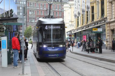 Helsinki, Finlandiya - 5 Eylül 2023: Aleksanterinkatu Caddesi 'ndeki Stockmann mağazasının önünde duran mavi tramvay ve Gigantti için ilan.