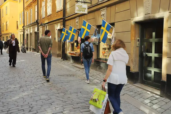 Stockholm, İsveç - 30 Nisan 2024: Old Town Hediyelik eşya dükkanındaki Skomakargatan Caddesi 'ndeki insanlar.