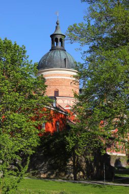 One tower of the 16th century Gripsholm castle imbedded in lush greenery. clipart