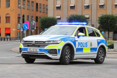 Stockholm, İsveç - 29 Temmuz 2024: Volkswagen Touareg Gustav Adolfs Meydanı 'nda işaretli İsveç polis arabası.