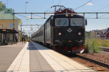 Hedemora, İsveç - 30 Temmuz 2024: Stokholm 'den gelen elektrikli lokomotif sınıfı Rc6 1417 ile çekilen SJ Intercity treni.