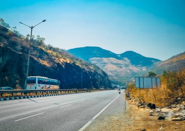 Otoyoldaki araçlar varış noktasına doğru seyahat ediyor ve büyük dağ sırasına bakıyor. 