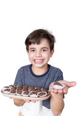 9 yaşındaki Brezilyalı elinde bir tepsi dolusu Brezilya çikolatası ve diğer elinde sadece şeker var..