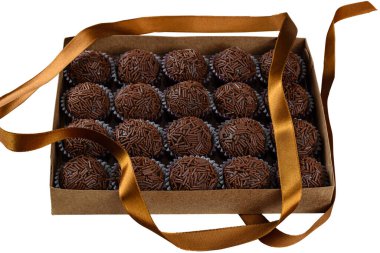 Box with several brigadeiros lined up next to a ribbon. Brazilian traditional sweet_white background. clipart