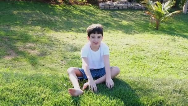 9岁的巴西人倒在花园里的一座小山上 — 图库视频影像