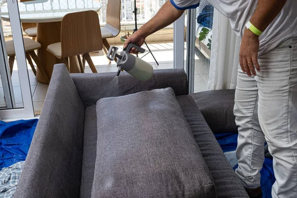 Adam, temiz ve su geçirmez kanepe yastıkları için sıvı dolduruyor..