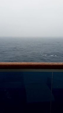 Deniz, tedirgin, yağmurlu bir günde bir yolcu gemisinin kabininden filme çekiliyor..