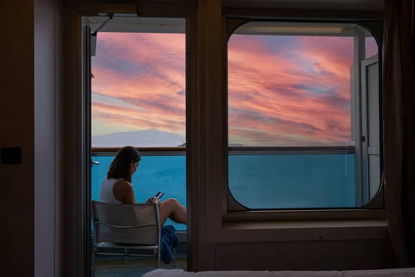 42 yaşındaki Brezilyalı kadın, yolcu kabininin balkonunda, akıllı telefonuyla iletişim kuruyor..