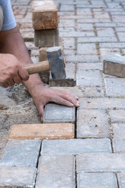 Brezilyalı ve inşaat işçisi beton blokta küçük bir tokmağa dokunuyor _ dikey.