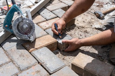Brezilya 'lı ve inşaat işçisi, beton testereyle kesilecek bloğu grafit kalemle işaretliyor..