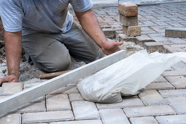 Brezilyalı ve inşaat işçisi beton blokların seviyesini kontrol etmek için cetvel kullanıyor.