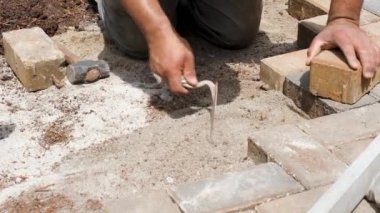 Brezilya 'lı ve inşaat işçisi kum tabanını düzleştirmek için mala ve tokmak kullanıyor..