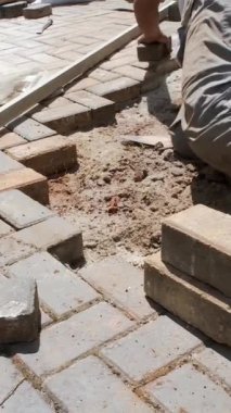 Brezilyalı ve inşaat işçisi toprağı kumla düzleştirmek ve bloğu düzleştirmek için mala kullanıyor..