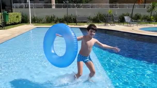 9岁的巴西人拿着浮标 走起路来很滑稽 还跳到游泳池里 — 图库视频影像