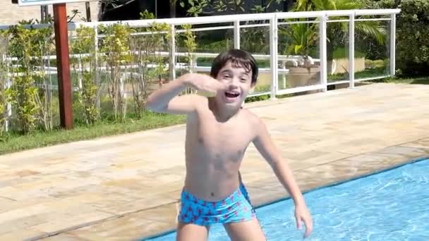 9岁的巴西人面带微笑 面对着摄像机 打电话到游泳池里潜水 — 图库视频影像