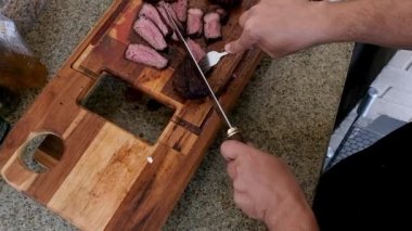 İnsanlara hizmet etmek için sığır filetosunu ince dilimlere ayıran bir adam..