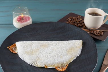 Eritilmiş mozzarella peynirli tapyoka, bir fincan sade kahvenin yanında mavi ahşap arka plan. Geleneksel Brezilya yemeği _ 8.