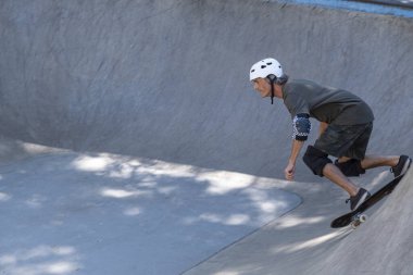 54 yaşındaki Brezilyalı kaykaycı güneşli bir günde kaykay parkında eğleniyor..