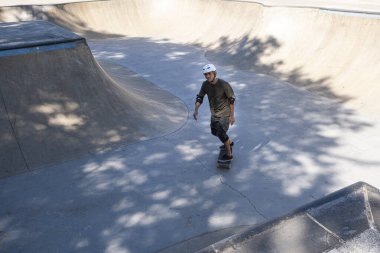 54 yaşındaki Brezilyalı kaykaycı güneşli bir günde kaykay parkında eğleniyor..