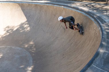 54 yaşındaki Brezilyalı kaykaycı güneşli bir günde kaykay parkında eğleniyor..