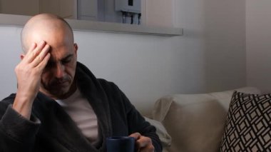 48 yaşında Brezilyalı bir adam, eli başının üstünde, çay içiyor ve başı ağrıyor..