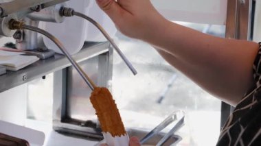Dul de leche _ 4 ile doldurmak için enjektör başlığına churros koyan kadın.