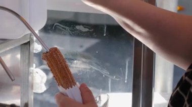 Çikolata kremi ile doldurmak için enjektör başlığına churros koyan kadın _ 5.