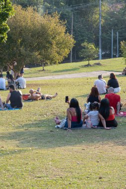 SAO PAULO, SAO PAULO - BRAZIL, AĞUSTOS 18, 2024: Sunset Square 'de aileleriyle birlikte gün batımını bekleyen farklı insanlar _ 3.