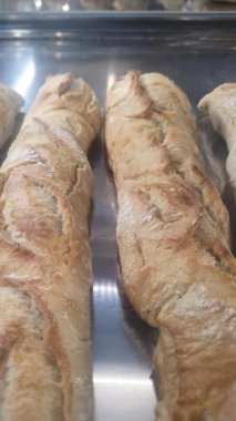 Brezilya 'daki bir fırında cam ekranda sergilenen Fransız rulosu _ dikey.