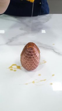 Şekerci çikolatalı süt yumurtasına bal koyuyor..