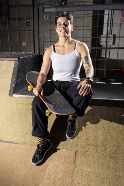 26 yaşında Brezilyalı bir kız terasta oturmuş ve patenini tutuyor..