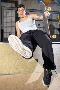 26 yaşında Brezilyalı bir kadın oturuyor ve ayakkabısının tabanını dikey gösteriyor..