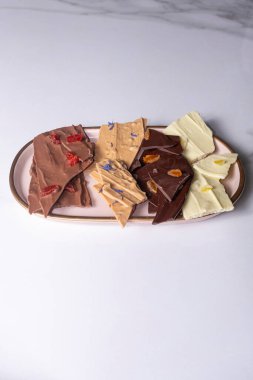 Farklı aromalı çikolata parçacıkları tabakta _ dikey.