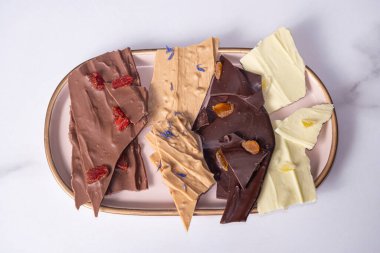 Farklı aromalı çikolata parçacıkları tabakta _ üstten görünüm.