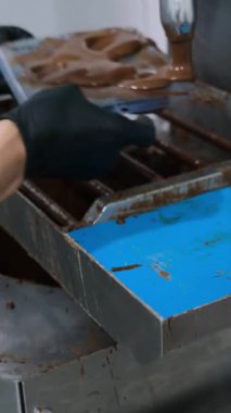 Yuvarlak çikolata kabukları yapan küçük bir fabrikanın çalışanı..