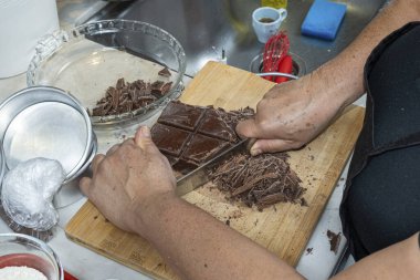 Pasta şefi çikolatayı doğradı. Turta yapmak için..