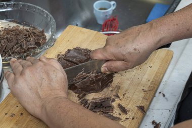 Pasta şefi pasta doldurmak için çikolata doğruyor..
