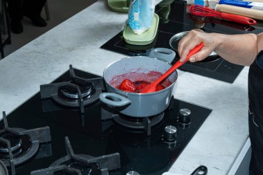 Şefin asistanı turta için çilek sosu yapıyor..