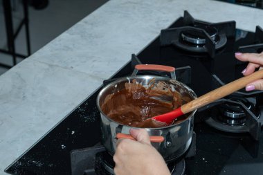 Pastayı doldurmak için çikolatayı eriten şef..