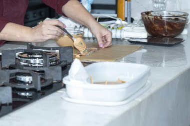 Şef karamelli çikolatayla narin bir dekorasyon yapıyor..